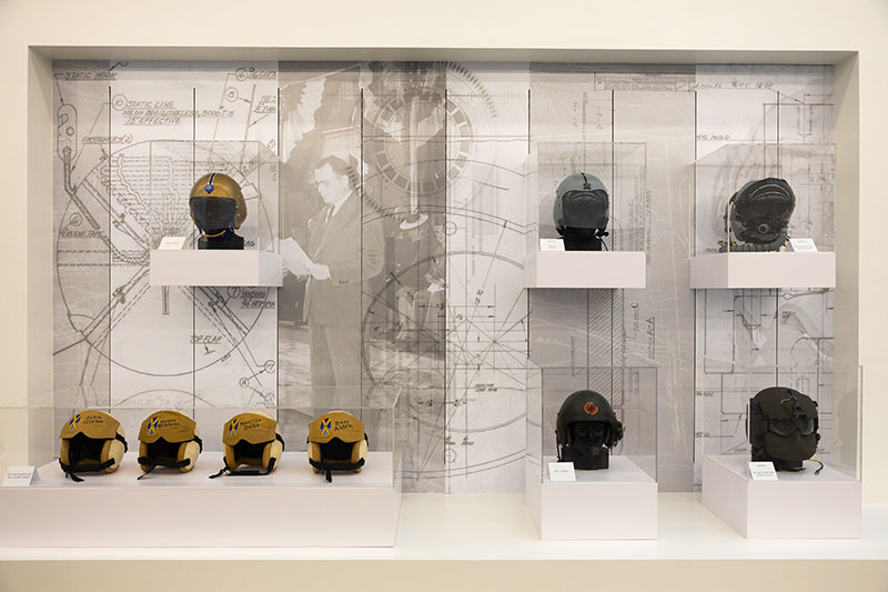 A display case showcases several of Gentex helmets. 