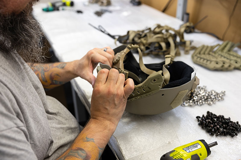 A male employee assembles a helmet. 