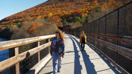 Two women cross the bridge over the Lehigh River at Lehigh Gorge State Park in Weatherly, PA.