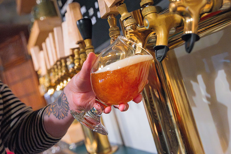A bartender pours a golden beer from the tap at Blind Cat beer Co. in Pittston, PA.
