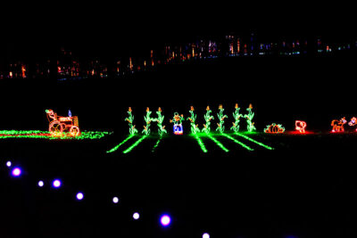 A holiday light display featuring a glowing agricultural scene at Stone Hedge Golf Course during the Festival of Lights in Tunkhannock PA.