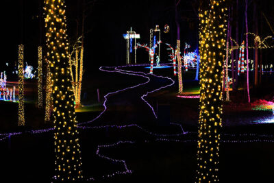 A holiday light display shows a glowing path between two trees at Stone Hedge Golf Course during the Festival of Lights in Tunkhannock PA.