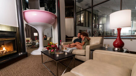 A man and women sitting on a comfortable sofa in their room at Cove Haven Resort in Lakeville, PA.