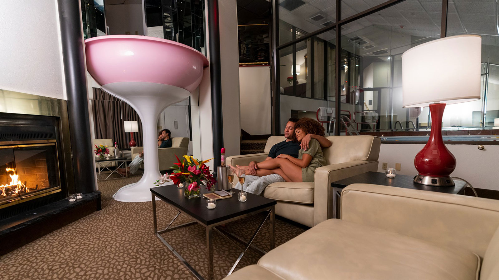 A man and women sitting on a comfortable sofa in their room at Cove Haven Resort in Lakeville, PA.