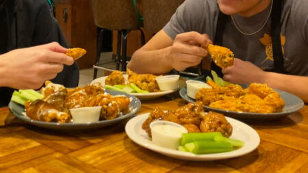 Two people eating hot wings from Mountain Top Pub and Eatery in Mountain Top, PA.