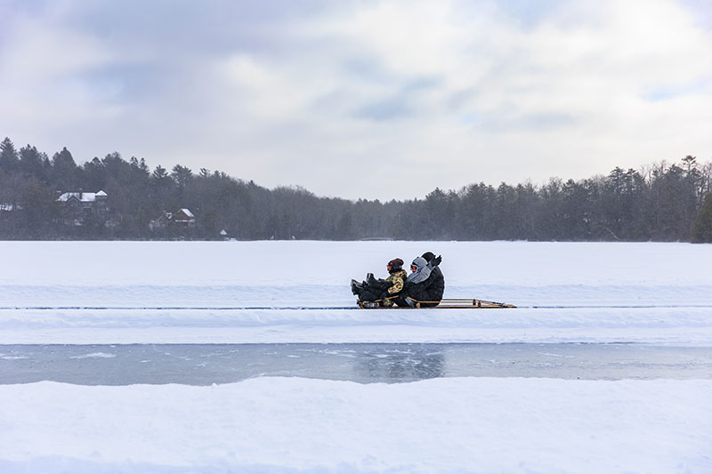 A family zooms by on a toboggan across the ice in Eaglesmere, PA.