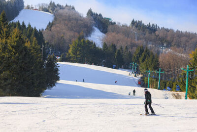 Image taken from the bottom of hill looking up at skiers coming down the mountain at Elk Mountain in Union Dale, PA.