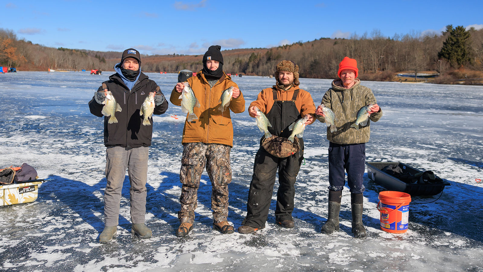 Four men holding two fish each caught during Nanticoke Conservation Club's Ice Fishing Derby at Frances Slocum State Park in Wyoming, PA.