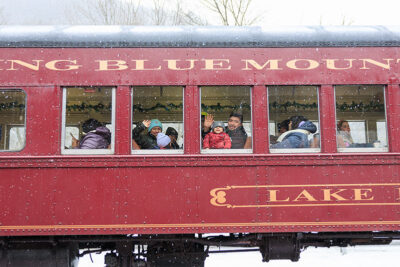 People waving while sitting on the train during Winterfest in Jim Thorpe, PA