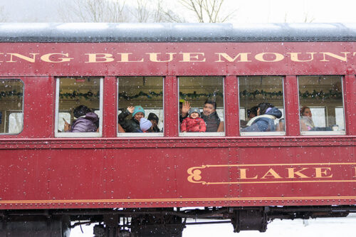 People waving while sitting on the train during Winterfest in Jim Thorpe, PA