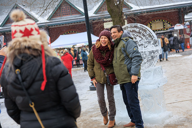 A man and woman pose in front of an ice sculpture during Winterfest in Jim Thorpe, PA
