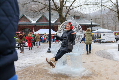 A woman poses in front of an ice sculpture during Winterfest in Jim Thorpe, PA