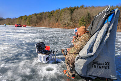 Two men fishing on the ice during Nanticoke Conservation Club's Ice Fishing Derby at Frances Slocum State Park in Wyoming, PA.