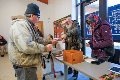 A man hands out tickets for the 50/50 raffle during Nanticoke Conservation Club's Ice Fishing Derby at Frances Slocum State Park in Wyoming, PA.