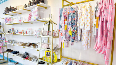 A collection of bright colored kids' pajamas, shoes, and toys from Baby Vogue in Kingston, PA.