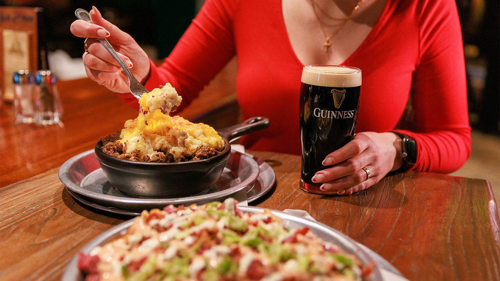 A woman dips into cottage pie while holding a guinness at Molly O'Sheas in Wilkes-Barre, PA.