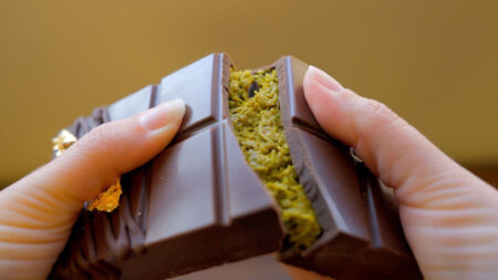 A Dubai chocolate bar being broken in half to show the crunchy, pistachio center at Queen of Tarts in Archbald, PA.
