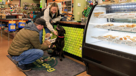 A man and woman pose with their dogs at Green Dog Barkery, a local dog bakery in Wyoming, PA.