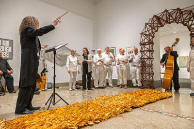 A conductor leads a choir in song at the Everhart Museum in Scranton, PA.
