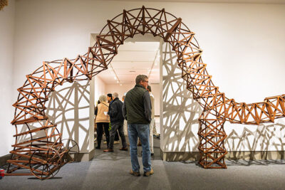 A man about to walk under a piece of artwork resembling a wooden track and that outlines a doorway at the Everhart Museum in Scranton, PA.