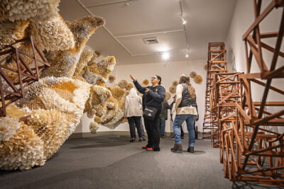 A man and woman acknowledge a massive piece of artwork that is made entirely of rolled up paged from a book at the Everhart Museum in Scranton, PA.