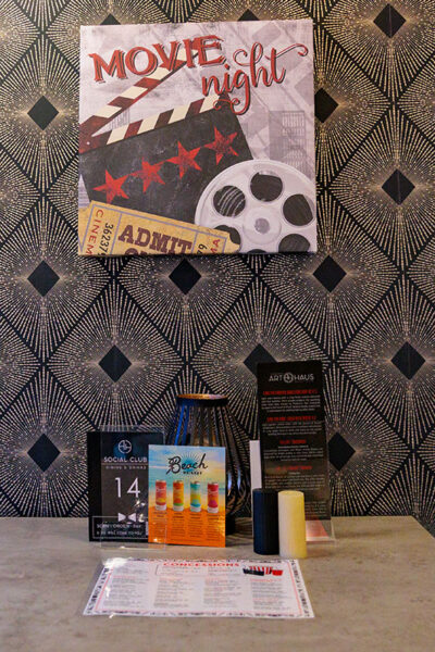 A placemat, salt and pepper shakers, and menus sit on a restaurant table as a sign reading 