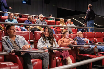 A man and woman are engaged in a friendly conversation as they sit in a movie theater at the Scranton Art Haus in Scranton, PA.
