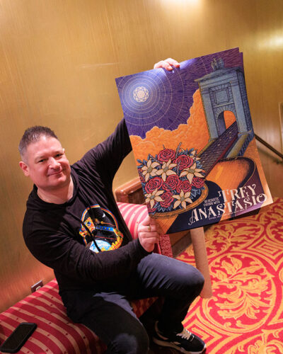 A man holds up a Trey Anastasio poster for a photo inside the F.M. Kirby Center for the Performing Arts in Wilkes-Barre, P.A.