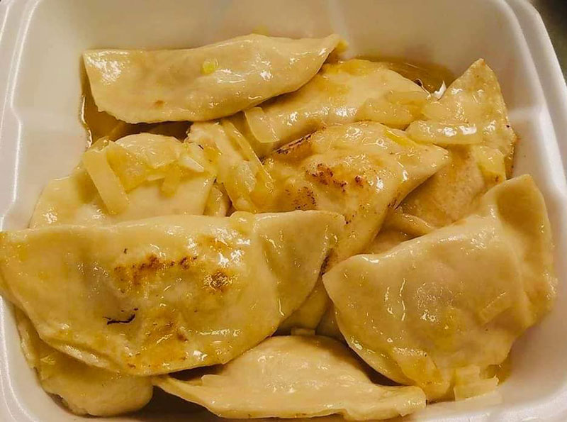 A plate of homemade pierogi covered in melted butter and onions at Polish Connection in Plymouth, PA.