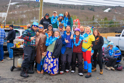 A group of men and women, tailgating, pose for the camera at Camelback Resort's 20th Pond Skim event in Tannersville, PA.
