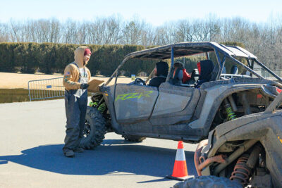A male guide reviews the saftey rules to three men sitting in an off-road vehicle at Pocono Outdoor Adventure Tours in Long Pond, PA.
