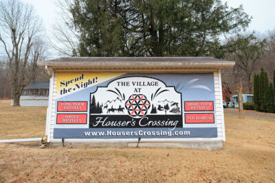 A sign posted on the backside of a white shed that reads 