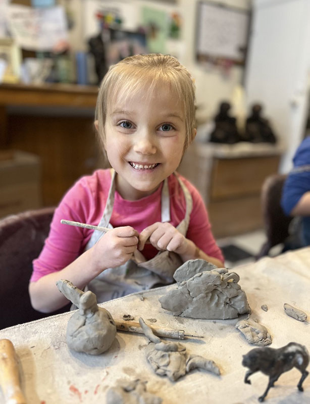 A young girl poses with her sculpting tools and a few of her creations during a Preschool Pottery Class at the Dietrich Theater in Tunkhannock, PA.