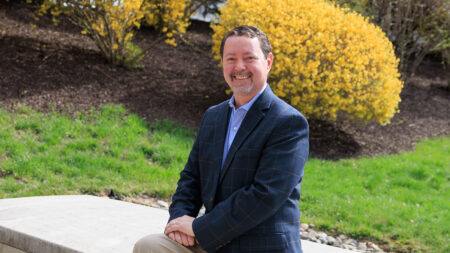 Tom Ruskey, Director of The Cancer Wellness Center of NEPA, stands in front of the building’s main entrance and signage.