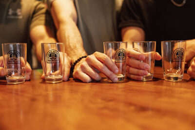 Empty beer glasses with Montage Mountain Brewfest logos are sitting on a table with hands around each glass during Brewfest at Montage Mountain in Scranton, PA.