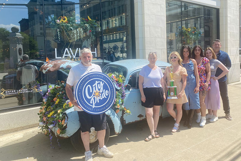 A group of people stand in front of a flower-filled Volkswagen Beatle during the Electric City Flower Show in Scranton, PA.