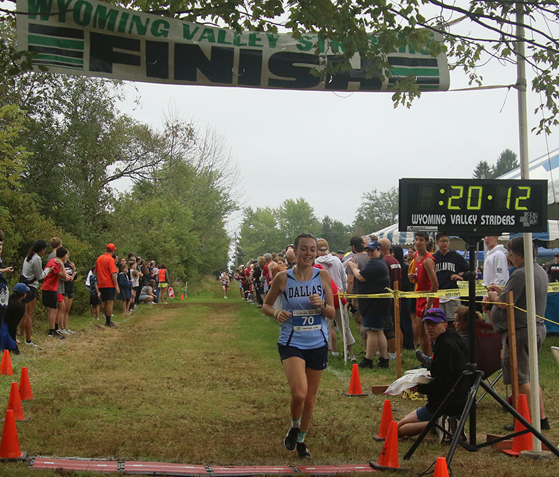 A female runner crosses the finish line at the Wyoming Valley Striders Cliff Robbins Race.