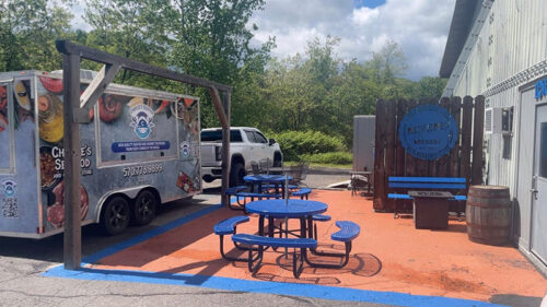 Blue tables and a food truck on the patio at Revere Brewery in Tamaqua, PA.