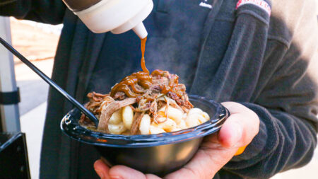 BBQ sauce being drizzled on top of pulled pork Mac and Cheese from Smoked and Sauced food truck while they were at Montage Mountain in Scranton, PA.