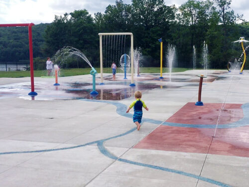 A boy running through the Splash Pad at Lackawanna State Park.