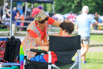 A woman paints a little boys face during the 2025 River of the Year celebration at Minisink Park in East Stroudsburg, PA.