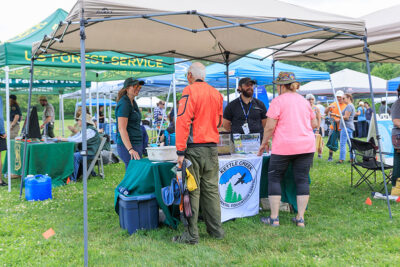 People engaged in conversation during the 2025 River of the Year celebration at Minisink Park in East Stroudsburg, PA.