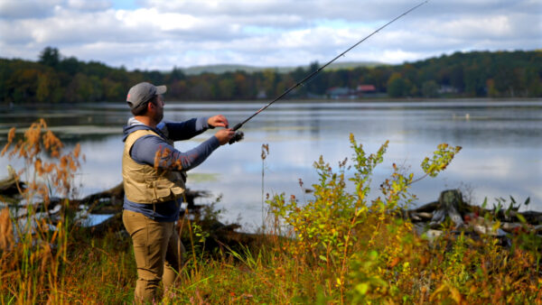 Man fishing at a lake in Northeastern Pennsylvania in a promotional video for GO WILD with DiscoverNEPA