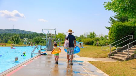 A father and son walk with along the edge of the pool with inner tubes at Frances Slocum State Park in Wyoming, PA, a popular place to swim in Northeastern PA.