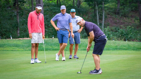 A man prepares to putt while three of his friends look on at Sand Springs Golf Course, a public golf course in Drums, PA.