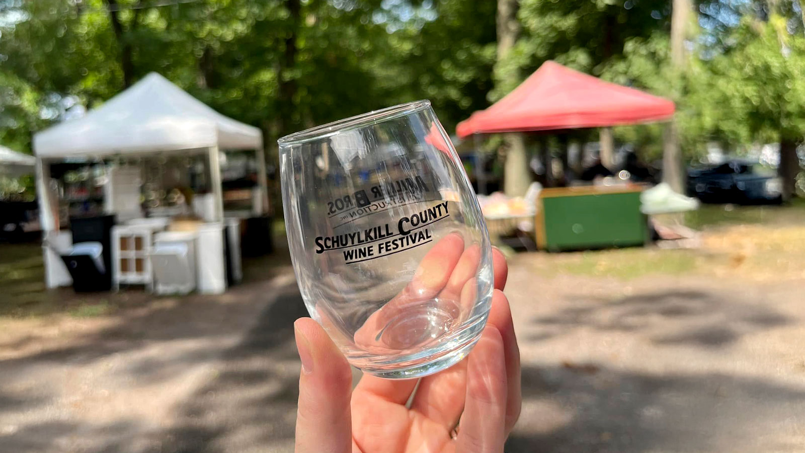 A hand holds a glass from the Schuylkill County Wine Festival held at Hegins Park in Hegins, PA.