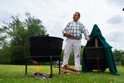 A man overseeing a demonstration of 19th century beer making