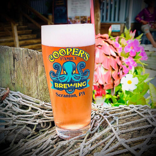A pint of cold beer on a railing on the outdoor deck at Cooper's Family Brewing in Scranton, PA.