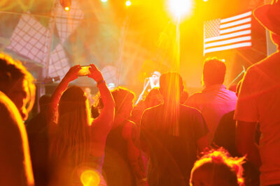A woman takes a photo of the band at the Briggs Farm Blues Festival in Nescopeck, PA.