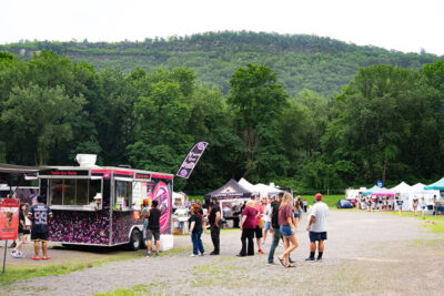 A crowd gathered by a food truck at the Garden Drive-In Theater